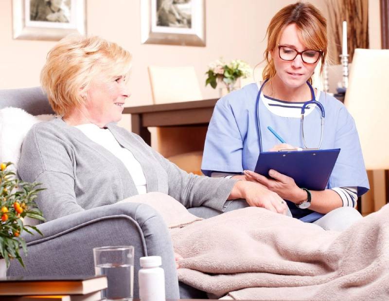 A woman sitting on the couch with another person.