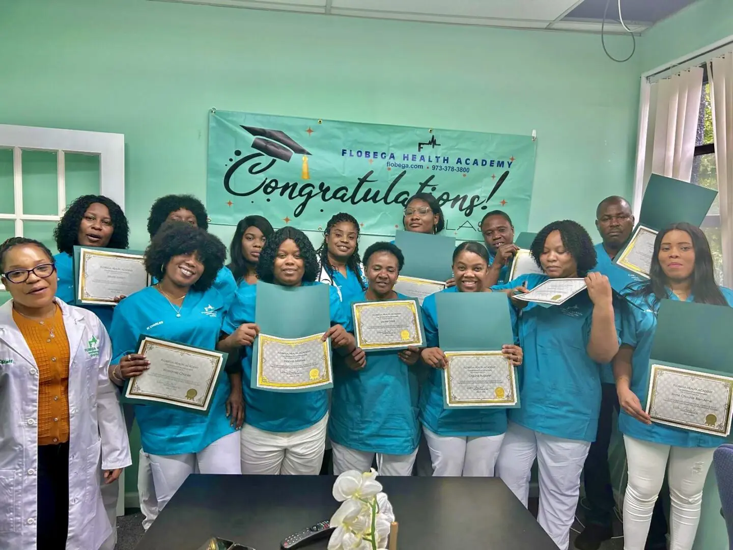 A group of people holding certificates in front of a sign.